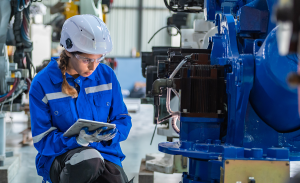 Woman engineer in uniform helmet inspection check control heavy machine robot arm construction installation in industrial factory. technician worker check for repair maintenance electronic operation.